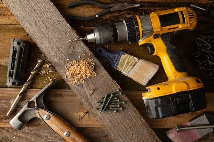Yellow power drill, screws and other tool